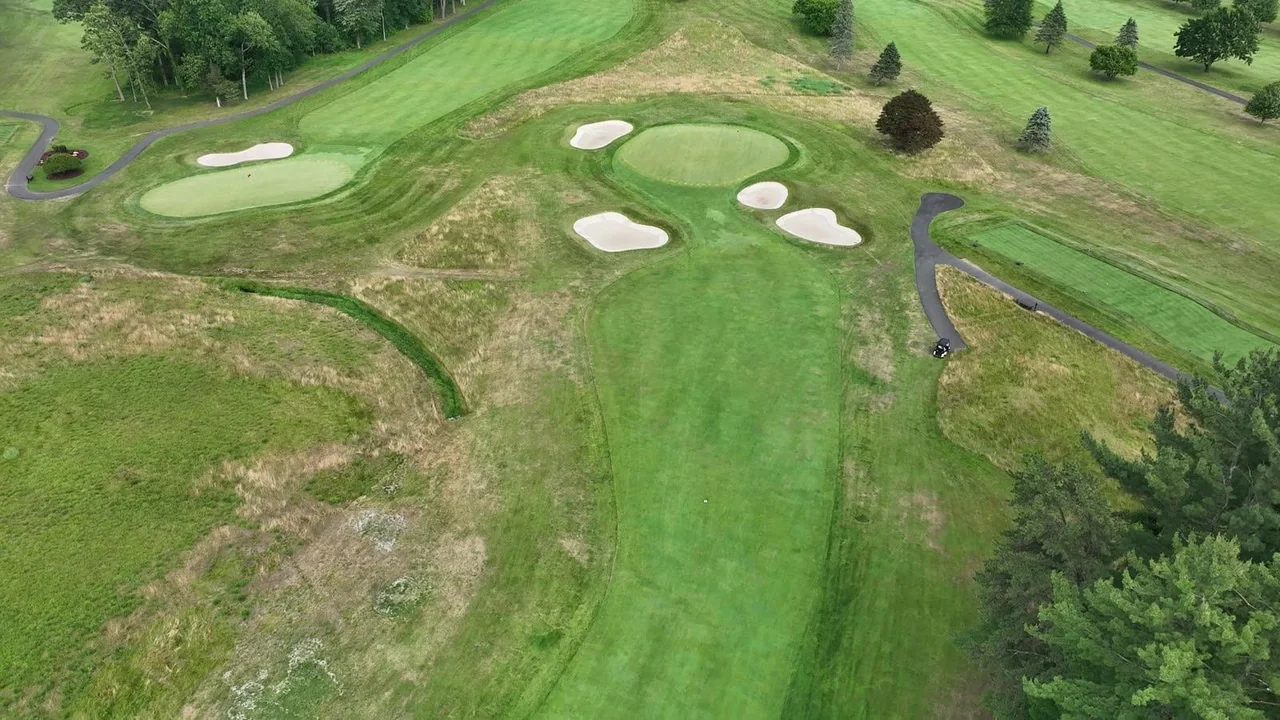 Overhead aerial of a green complex and surrounding bunkers